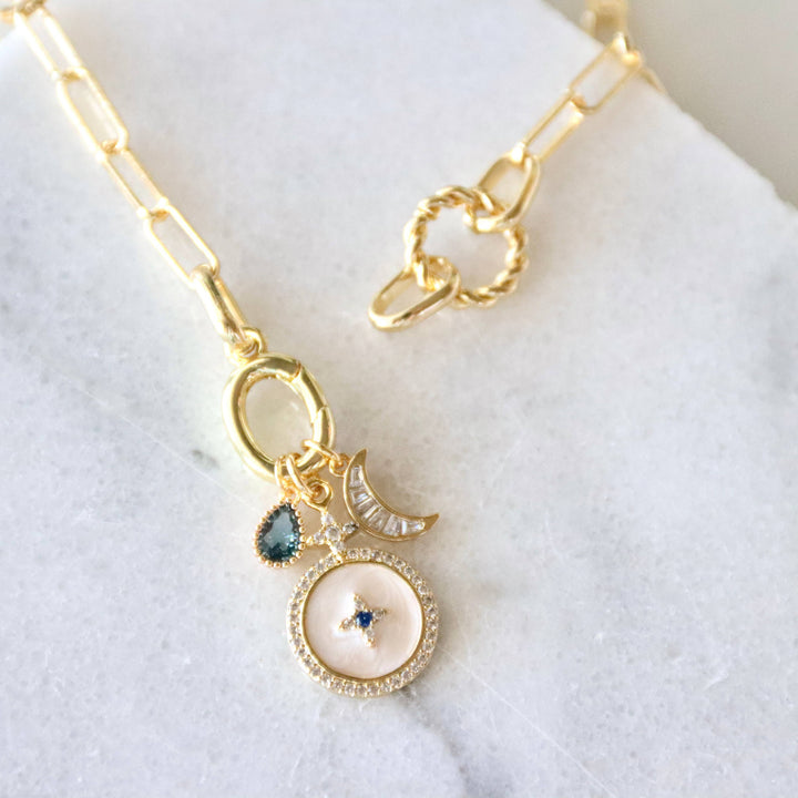 Gold necklace with a gemstone pendant on a white background