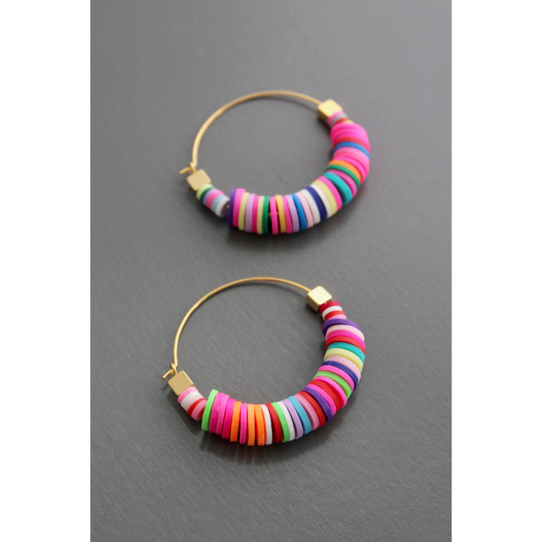 Colorful beaded hoop earrings on a gray background