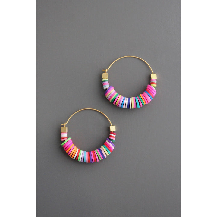 Colorful beaded hoop earrings on a gray background