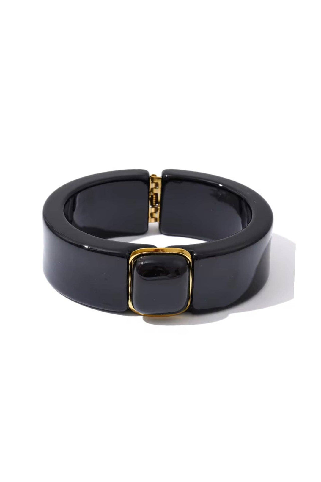 Black bracelet with gold accents on a white background
