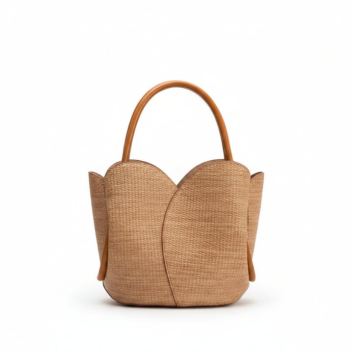 Brown woven raffia handbag with a handle on a white background