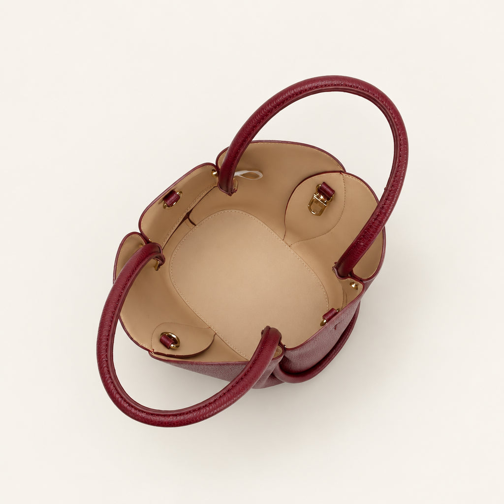 Small handbag with burgundy handles on a white background