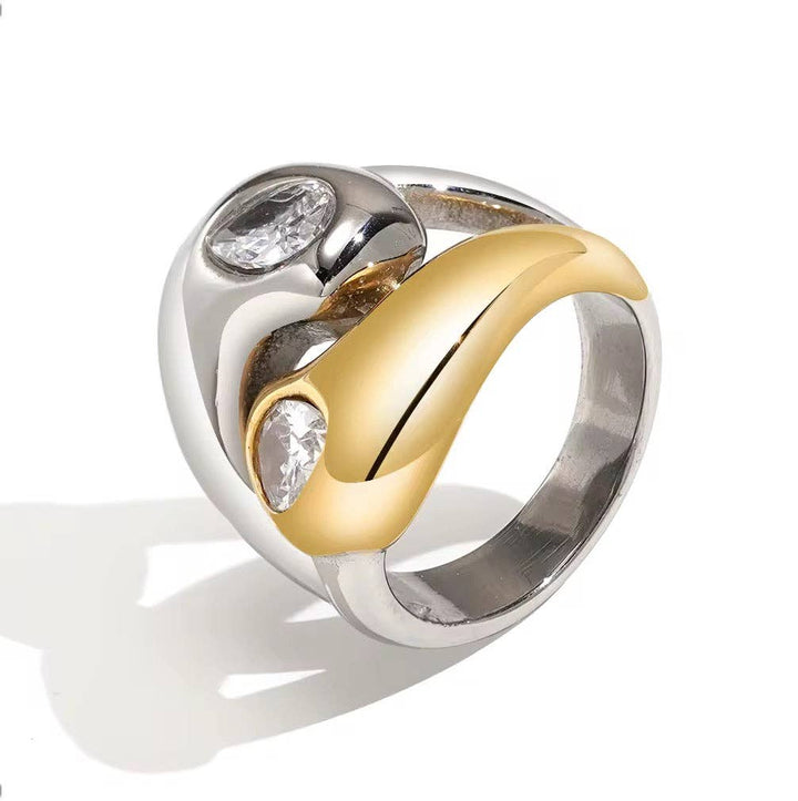Two-toned ring with silver and gold bands featuring embedded stones on a white background