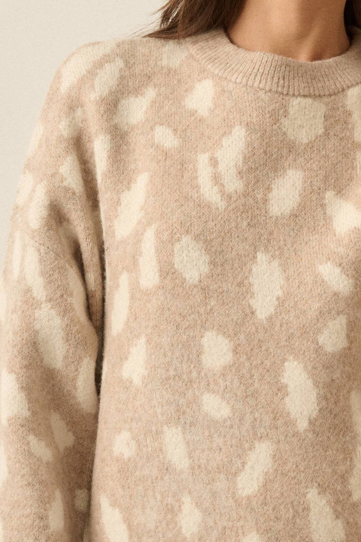 Close-up of a person wearing a fuzzy knit sweater in a warm beige color with a bambi print pattern, cropped from the neck to the upper torso against a plain light background.