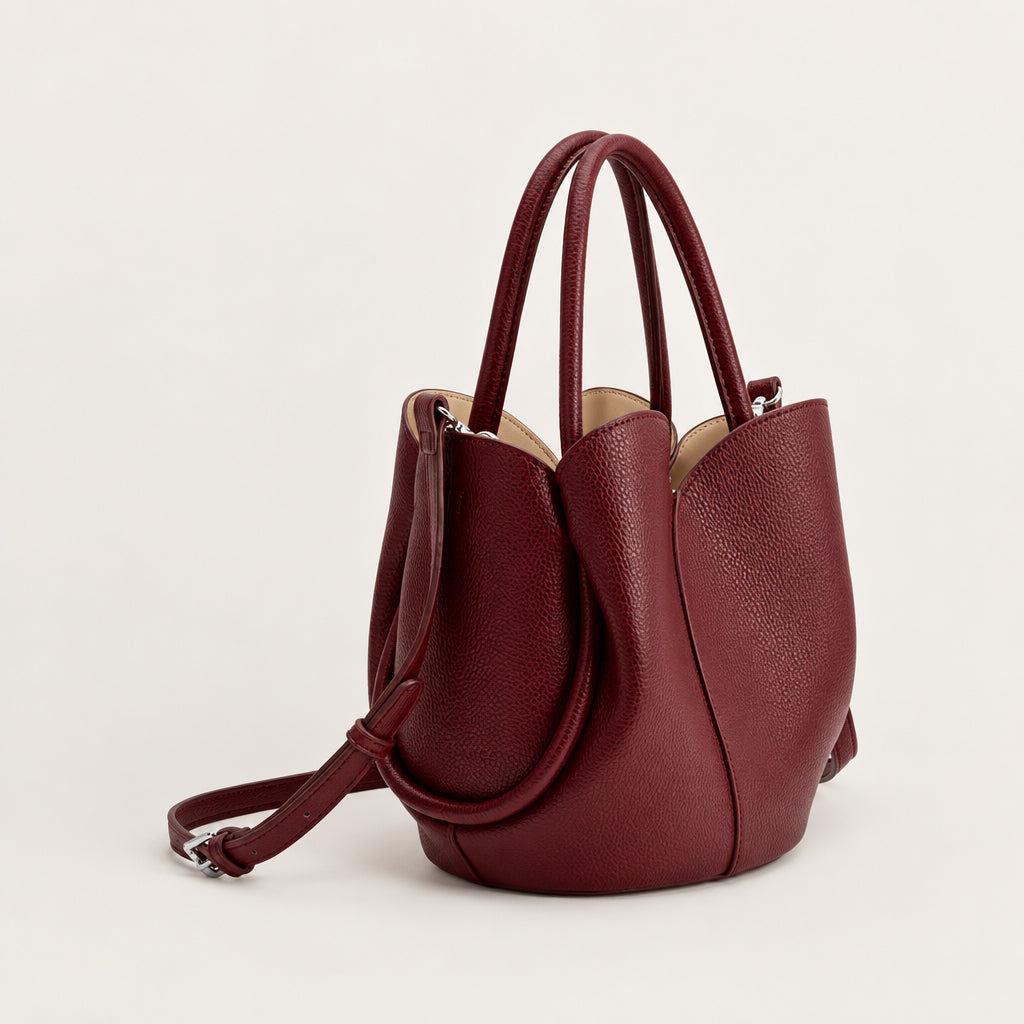 Burgundy faux leather crossbody bag with a strap on a white background