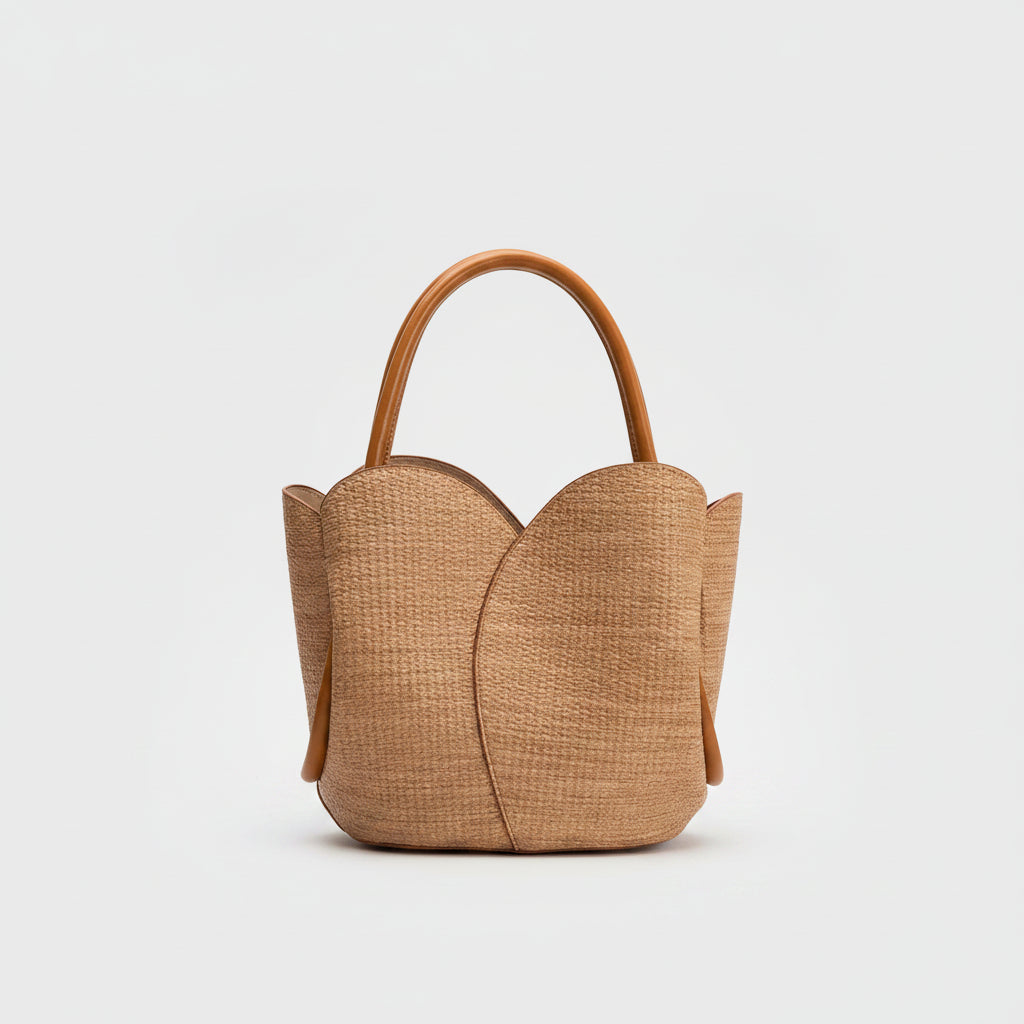 Brown woven raffia handbag with a handle on a white background