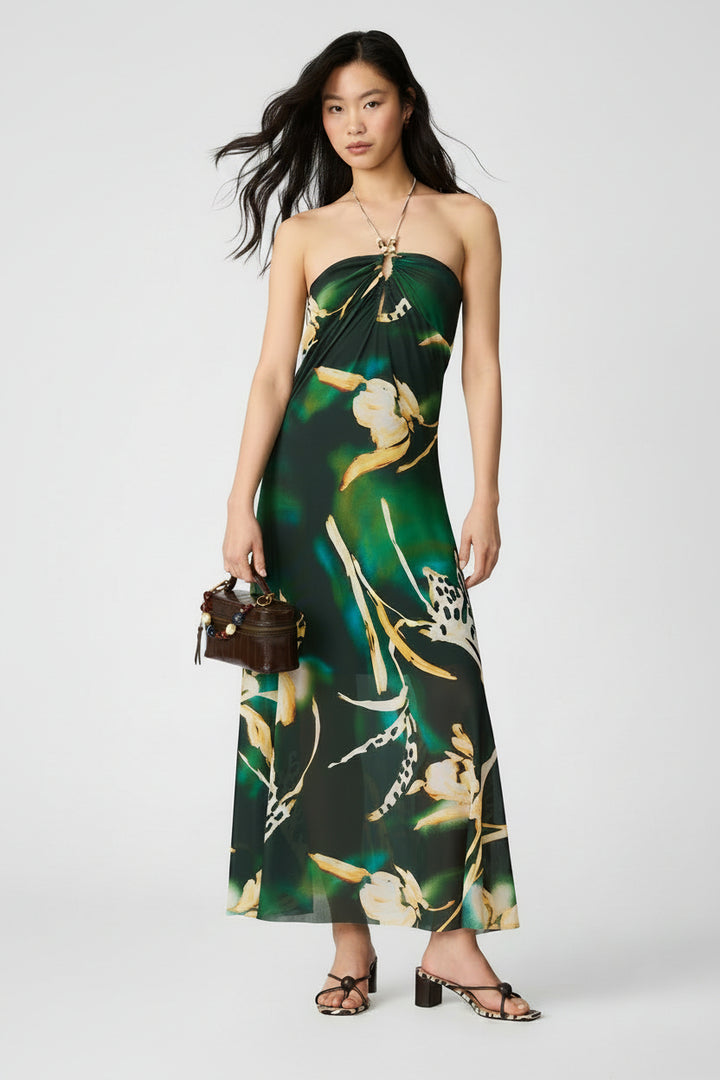 Woman wearing a strapless green and black floral dress on a white background